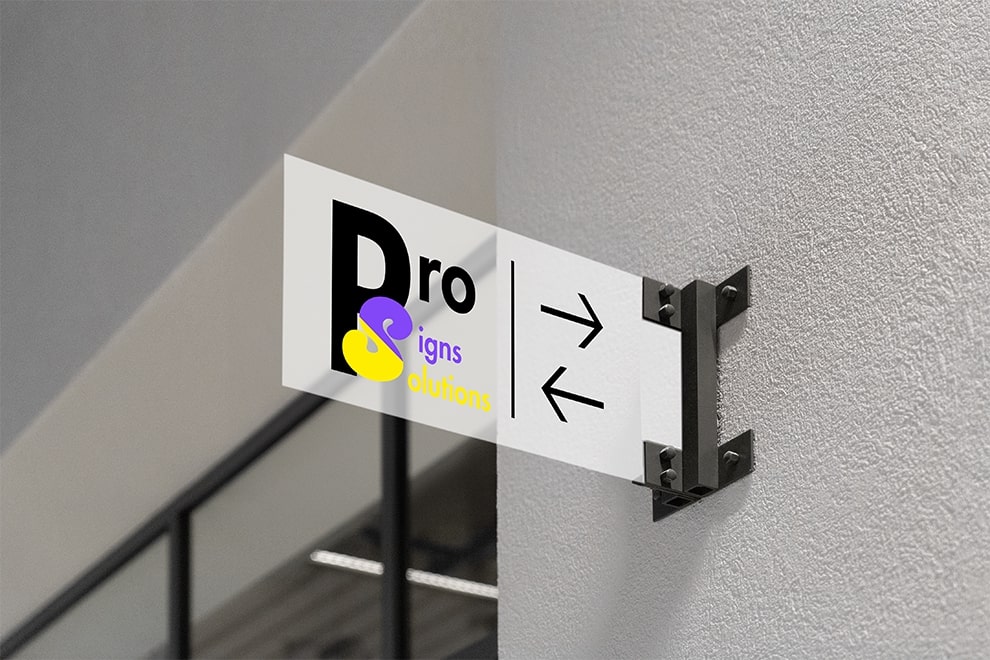 Pro Signs Solutions logo displayed on a clear acrylic projecting sign mounted to a wall with metal brackets, featuring directional arrows.